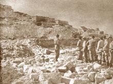 קבוצת לוחמים ליד חורבות הכפר ההרוס
